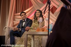 Indian bride and groom listening to the speeches