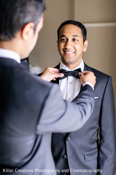 Indian groom being assisted with wardrobe Indian groom being assisted with wardrobe