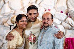 Indian groom posing with his parents Indian groom posing with his parents
