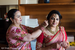 Indian bride putting her earrings on. Indian bride putting her earrings on.