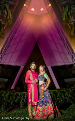 Indian bride and groom posing with their sangeet outfits. Indian bride and groom posing with their sangeet outfits.