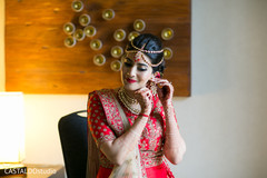 Dazzling Indian bride putting her earrings on. Dazzling Indian bride putting her earrings on.