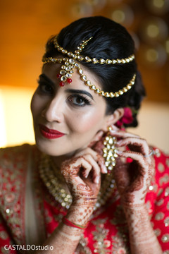 Indian bride putting earrings on. Indian bride putting earrings on.