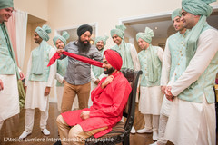 Indian groom being helped to get his turban on. Indian groom being helped to get his turban on.