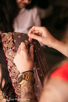Indian bride getting help to put her wedding Ghoonghat veil on. Indian bride getting help to put her wedding Ghoonghat veil on.
