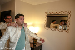 Indian groom being helped to get his sherwani. Indian groom being helped to get his sherwani.