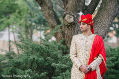 Indian groom posing outside by the trees Indian groom posing outside by the trees