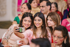 Beautiful Indian guests take pictures during the ceremony Beautiful Indian guests take pictures during the ceremony