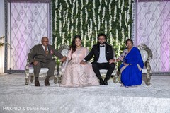 Indian bride and groom with parents posing for photo shoot Indian bride and groom with parents posing for photo shoot