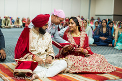 Lovely Indian bride garbing groom's ghoonghat. Lovely Indian bride garbing groom's ghoonghat.