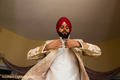 Indian groom putting his sherwani on. Indian groom putting his sherwani on.