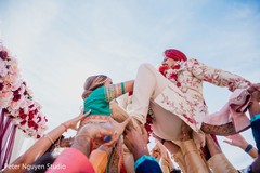 Indian groom being lifted by Indian groomsmen at baraat. Indian groom being lifted by Indian groomsmen at baraat.