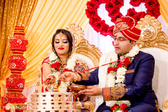 Indian bride and groom pouring offerings to sacred fire. Indian bride and groom pouring offerings to sacred fire.