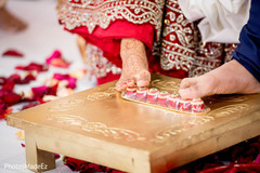 Indian bride and groom rolling betel nut with toes. Indian bride and groom rolling betel nut with toes.