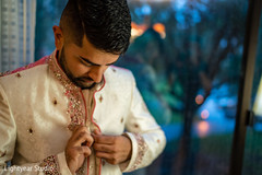 Indian groom putting his sherwani on. Indian groom putting his sherwani on.