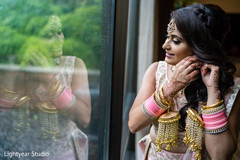 Indian bride putting earrings on. Indian bride putting earrings on.