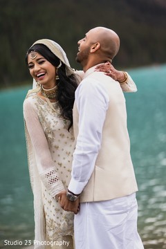 Indian bride and groom posing outdoors by the lake Indian bride and groom posing outdoors by the lake