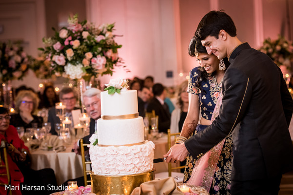 Indian bride and groom cutting the cake