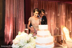 Lovely capture Indian bride and groom cutting cake together. Lovely capture Indian bride and groom cutting cake together.