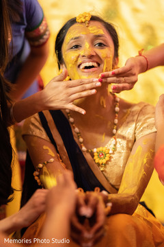 Indian bride getting the turmeric paste on her face. Indian bride getting the turmeric paste on her face.