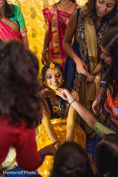 Indian bridesmaids putting turmeric paste on bride's face. Indian bridesmaids putting turmeric paste on bride's face.