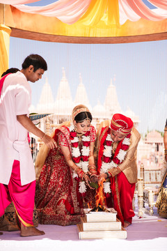 Indian bride and groom throwing the rice to sacred fire. Indian bride and groom throwing the rice to sacred fire.
