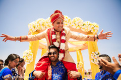 Indian groom lifted by a groomsmen at baraat procession. Indian groom lifted by a groomsmen at baraat procession.