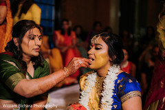 Indian bride getting the turmeric paste on her face. Indian bride getting the turmeric paste on her face.