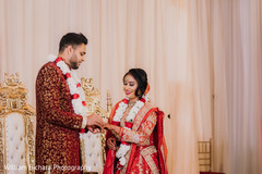 Indian groom putting wedding band to bride. Indian groom putting wedding band to bride.