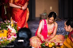Indian bride putting petals on offerings plate. Indian bride putting petals on offerings plate.