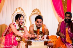 Indian bride and groom throwing the rice to sacred fire. Indian bride and groom throwing the rice to sacred fire.