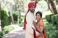 Indian bride and groom posing with their ceremony outfits. Indian bride and groom posing with their ceremony outfits.
