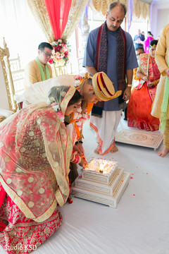 Indian couple pouring rice in to sacred fire. Indian couple pouring rice in to sacred fire.