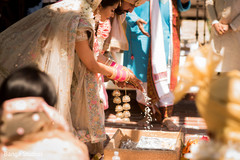 Maharani and raja pouring rice on to agni. Maharani and raja pouring rice on to agni.