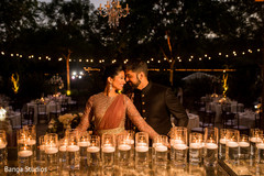 Indian bride and groom posing in front of candles. Indian bride and groom posing in front of candles.