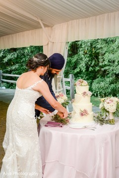 Indian bride and groom cutting the wedding cake Indian bride and groom cutting the wedding cake