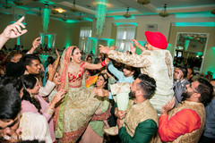 Indian couple being lifted by guests Indian couple being lifted by guests