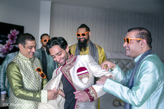 Indian groom putting his sherwani on. Indian groom putting his sherwani on.