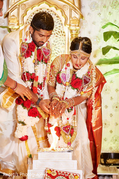 Indian couple poring rice into sacred fire. Indian couple poring rice into sacred fire.