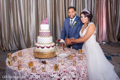 Indian bride and groom cutting cake scene. Indian bride and groom cutting cake scene.