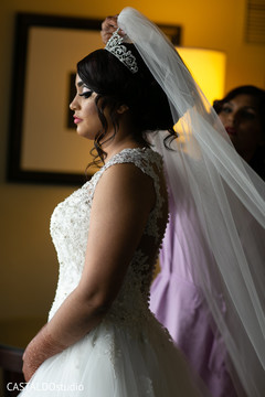 Indian bride putting her white veil on. Indian bride putting her white veil on.