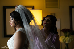 Indian bridesmaid putting bride her veil. Indian bridesmaid putting bride her veil.