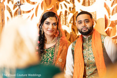 Indian bride and groom looking at the camera during Sangeet Indian bride and groom looking at the camera during Sangeet