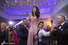 Indian bride being lifted up during reception. Indian bride being lifted up during reception.