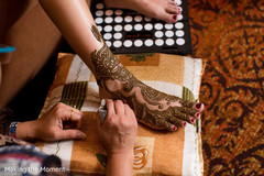 Indian bride being assisted with mehndi Indian bride being assisted with mehndi