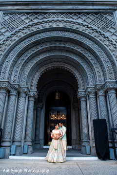 Indian couple posing at their wedding location entrance. Indian couple posing at their wedding location entrance.