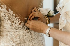 Maharani getting help to button her wedding dress. Maharani getting help to button her wedding dress.