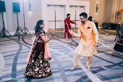 Indian couple using dandiya raas sticks at sangeet dance. Indian couple using dandiya raas sticks at sangeet dance.