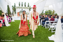 Indian bride and groom walking out from the ceremony isle. Indian bride and groom walking out from the ceremony isle.