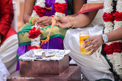 Indian groom putting oil to sacred fire. Indian groom putting oil to sacred fire.